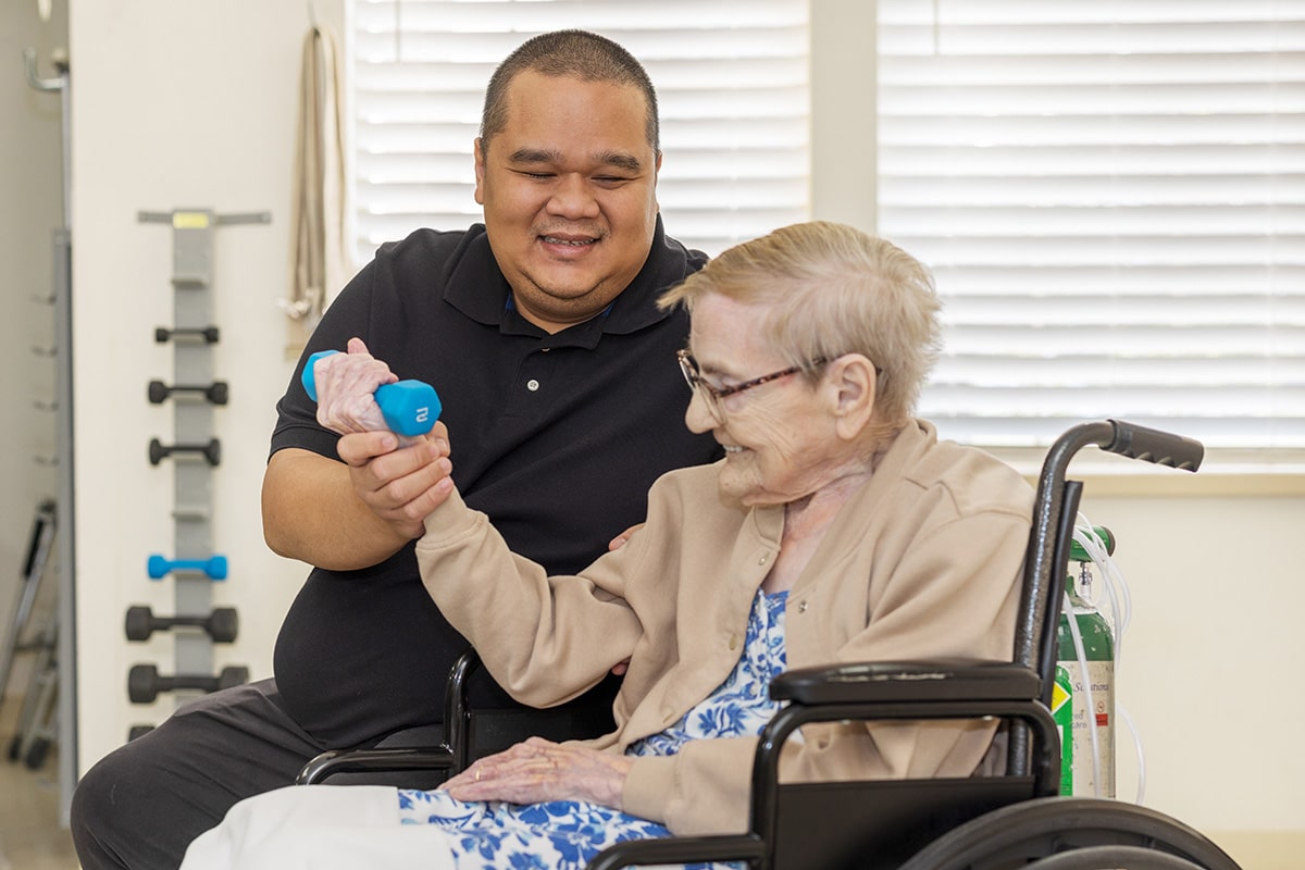 A rehab therapist with a resident in the Rehab gym of the Sundance Creek facility