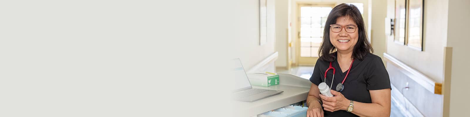 A nurse at a nurse's cart in the hallway at the Sundance Creek facility
