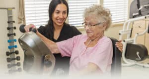 A rehab therapist with a resident in the Rehab gym of the Sundance Creek facility